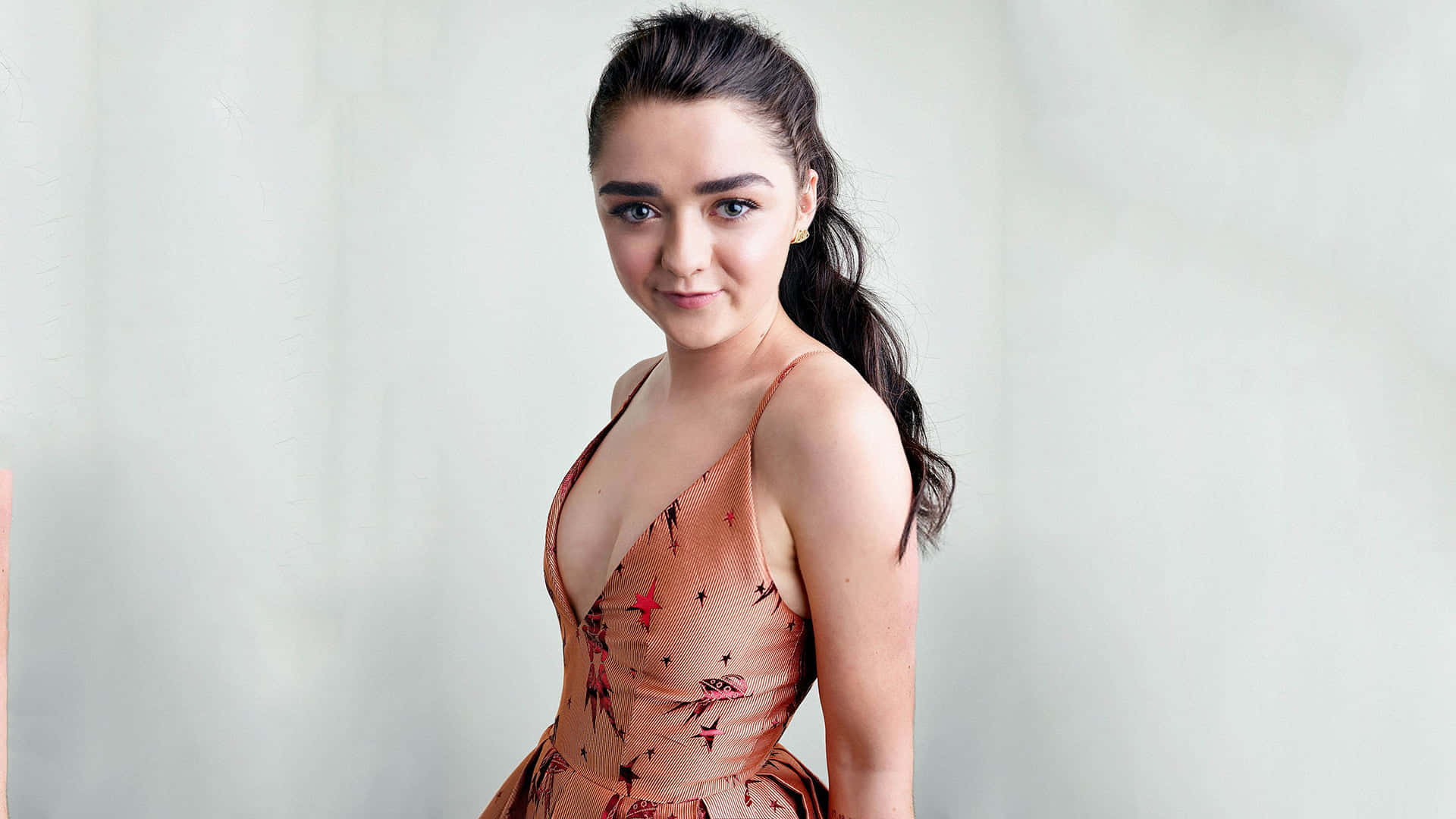 Download free Caption: Maisie Williams Wearing A Formal Dress And Smiling  At The Camera During An Event Wallpaper - MrWallpaper.com