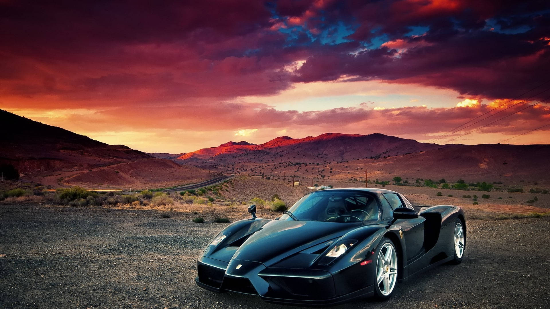Caption: Power Meets Elegance: Black Ferrari Conquering The Barren Land On An Ipad Screen Wallpaper