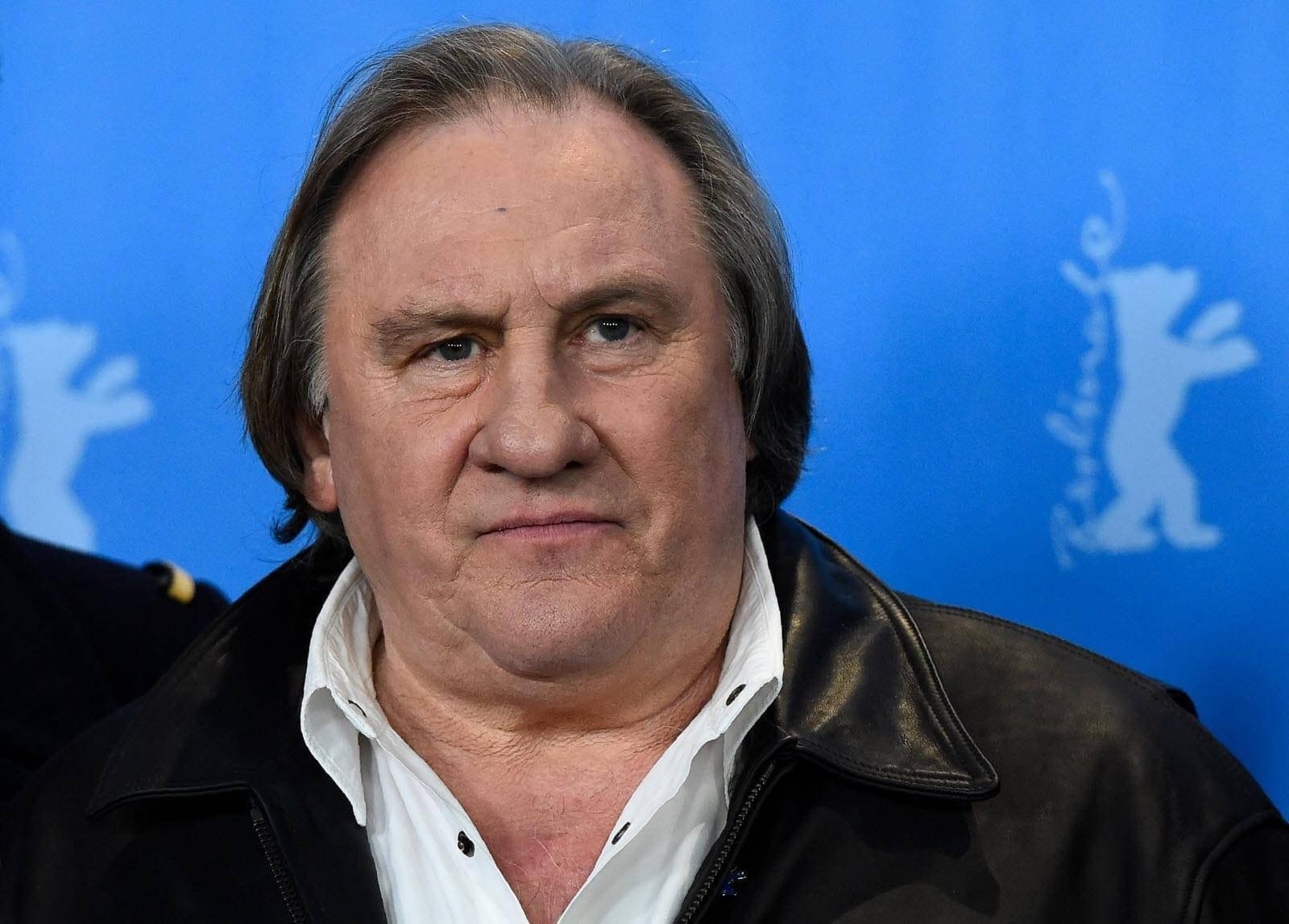 Caption: Renowned French Actor Gérard Depardieu Posing Against A Blue Background Wallpaper