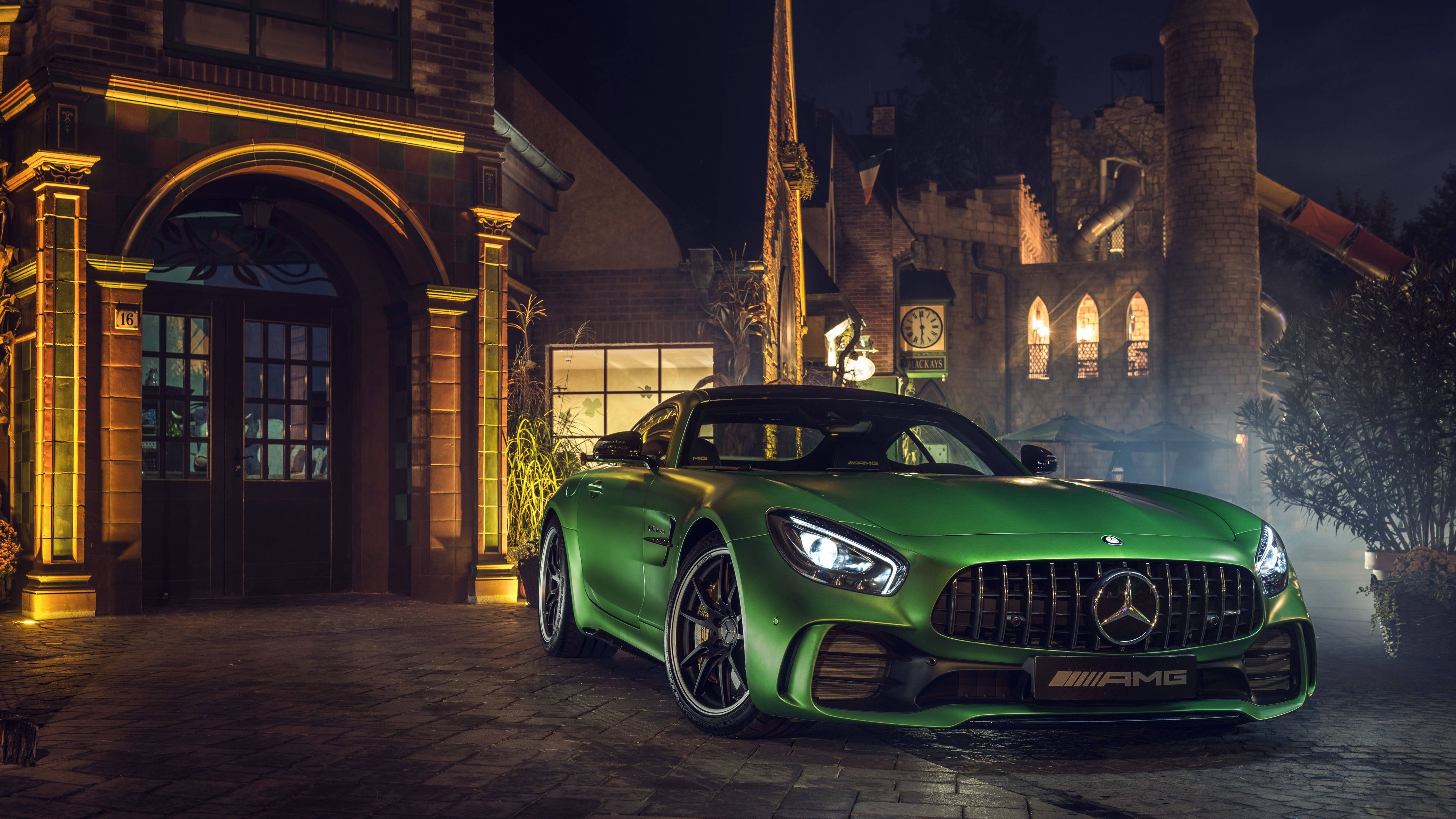Caption: Striking Elegance - A Mercedes-amg In A Captivating Green Hue Standing Outside A Modernistic Building. Wallpaper