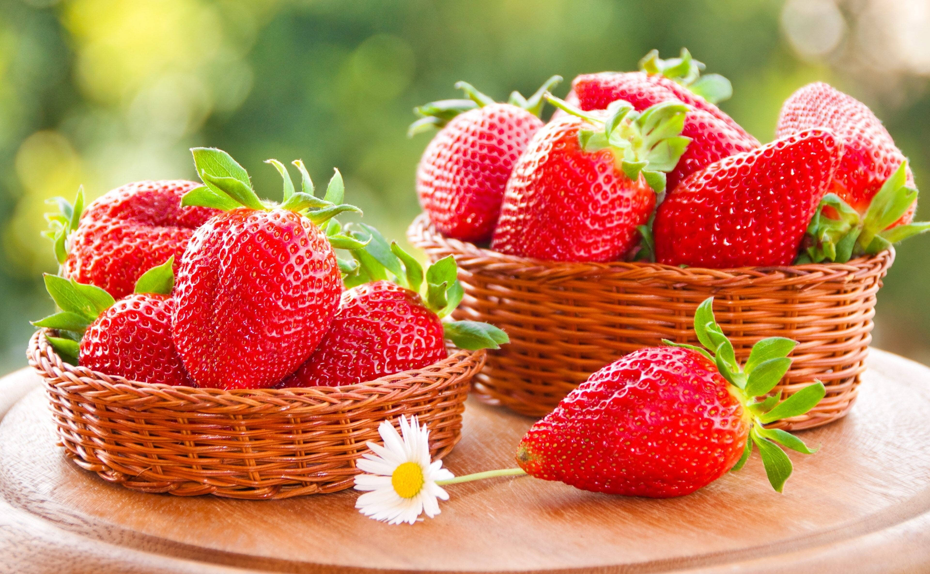 Caption: Vibrant Strawberries In Woven Baskets On A Desktop Wallpaper