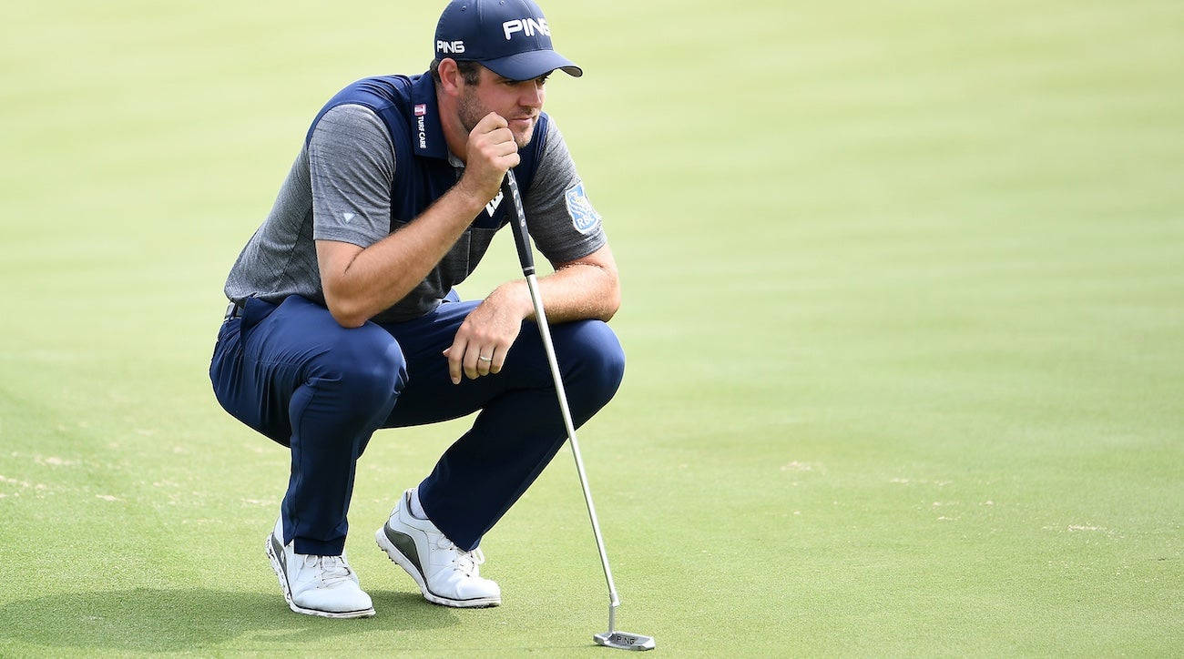 Corey Conners Squatting On A Golf Course Wallpaper