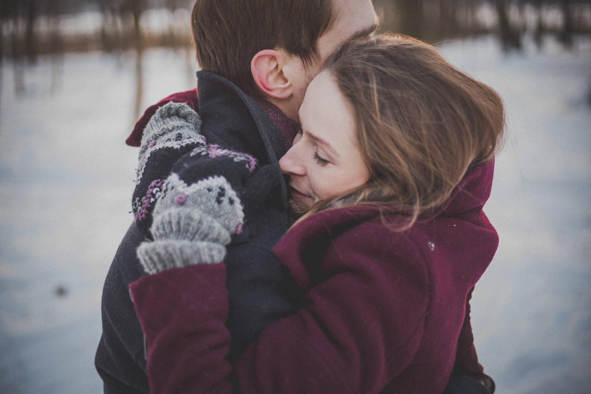 Couple Hugging In A Snow Forest Wallpaper