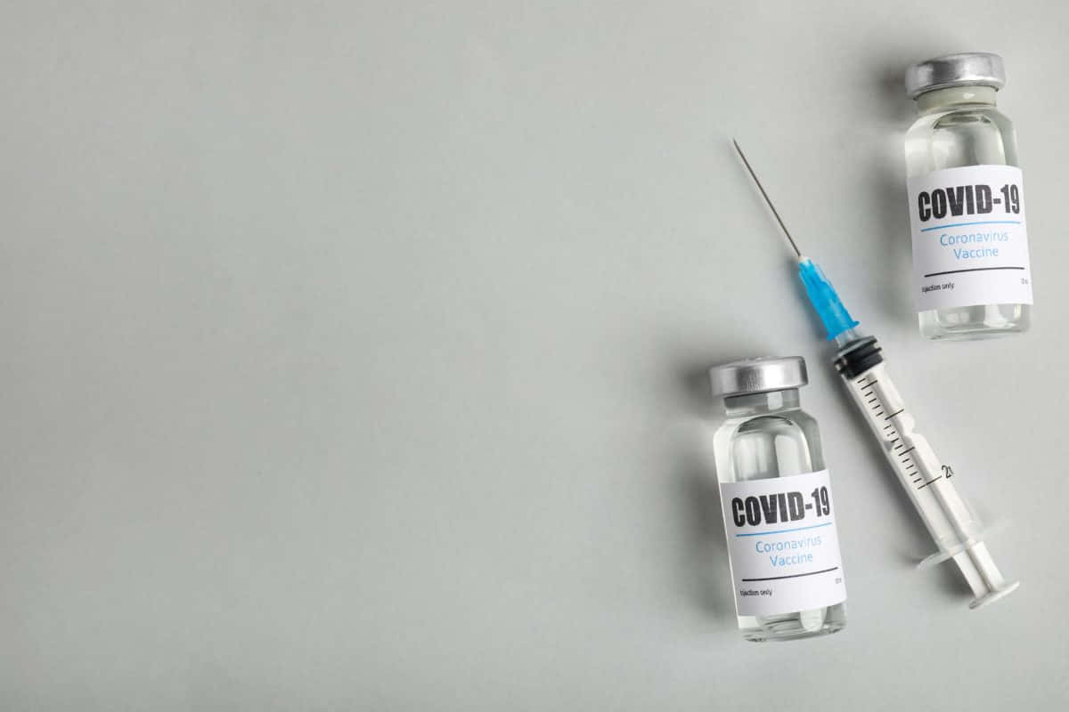 Covid-19 Vaccine Vials And Syringe Plain Background Wallpaper