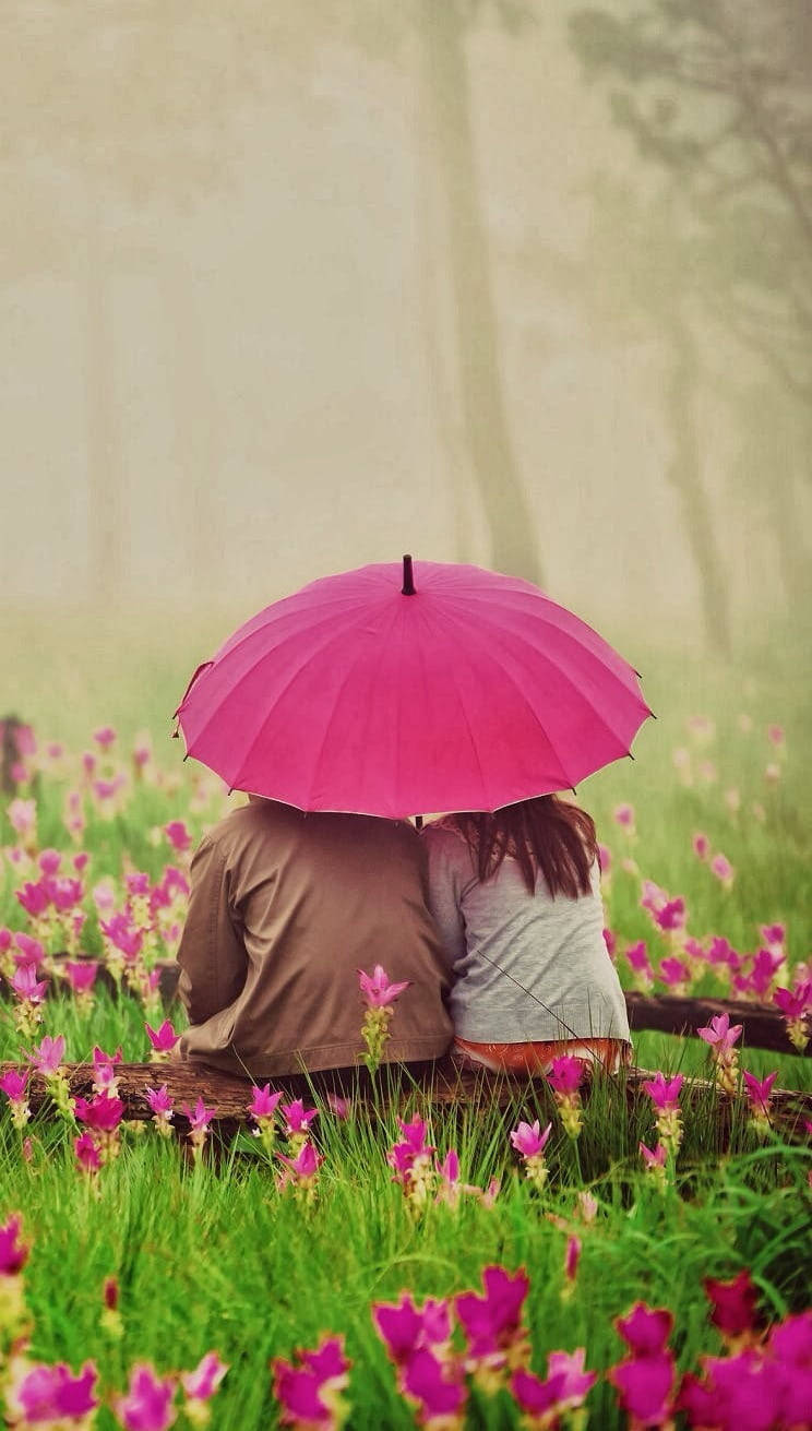 Cute Couple With Umbrella In Flower Garden Wallpaper