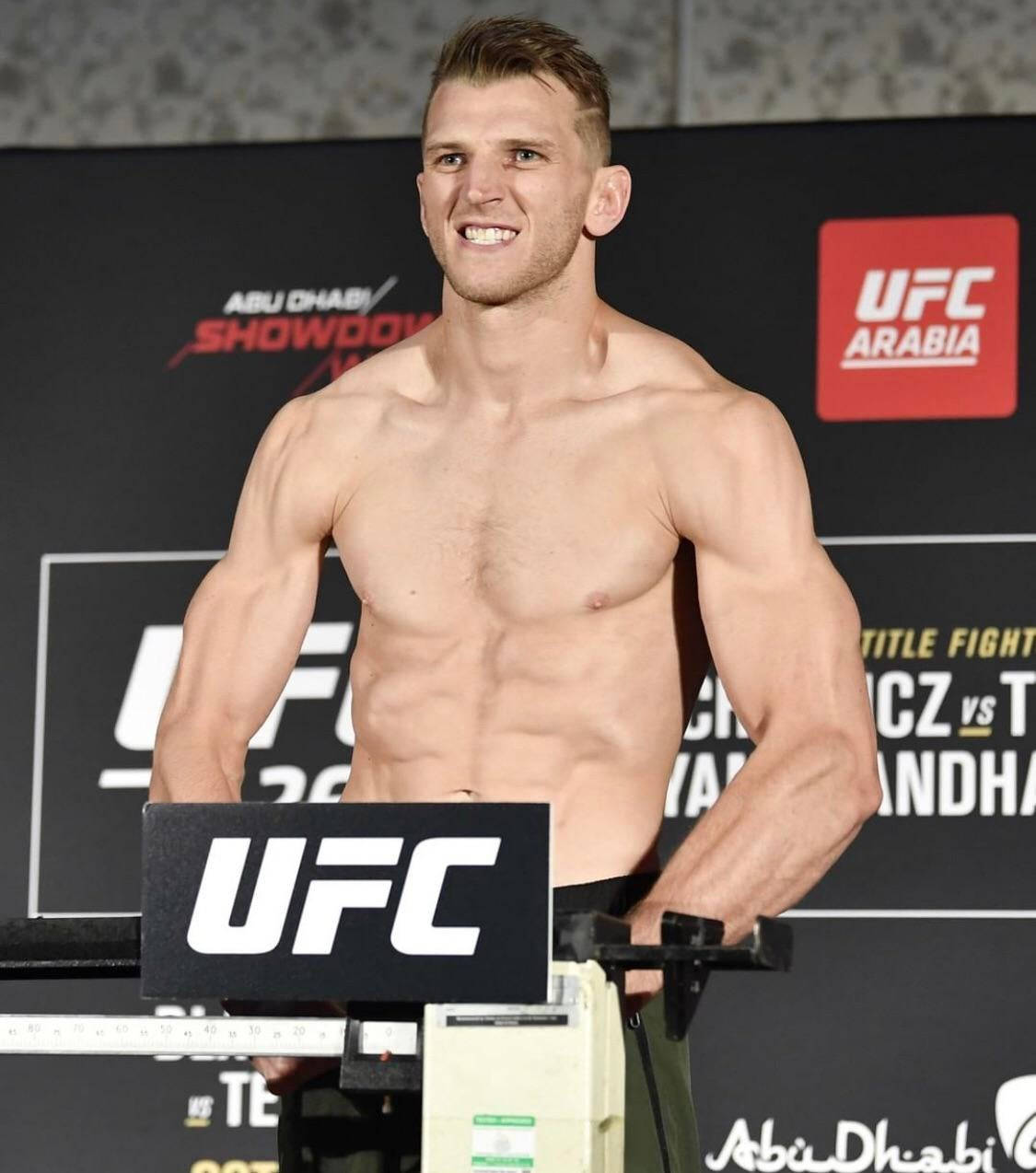 Dan Hooker Smiling On Scale Wallpaper