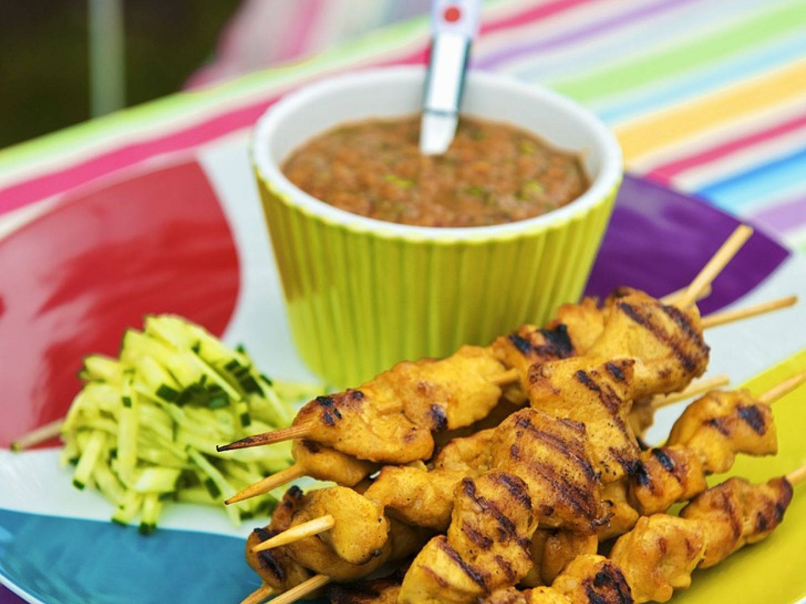 Delectable Chicken Satay Skewers With Peanut Sauce And Sliced Pickles Wallpaper