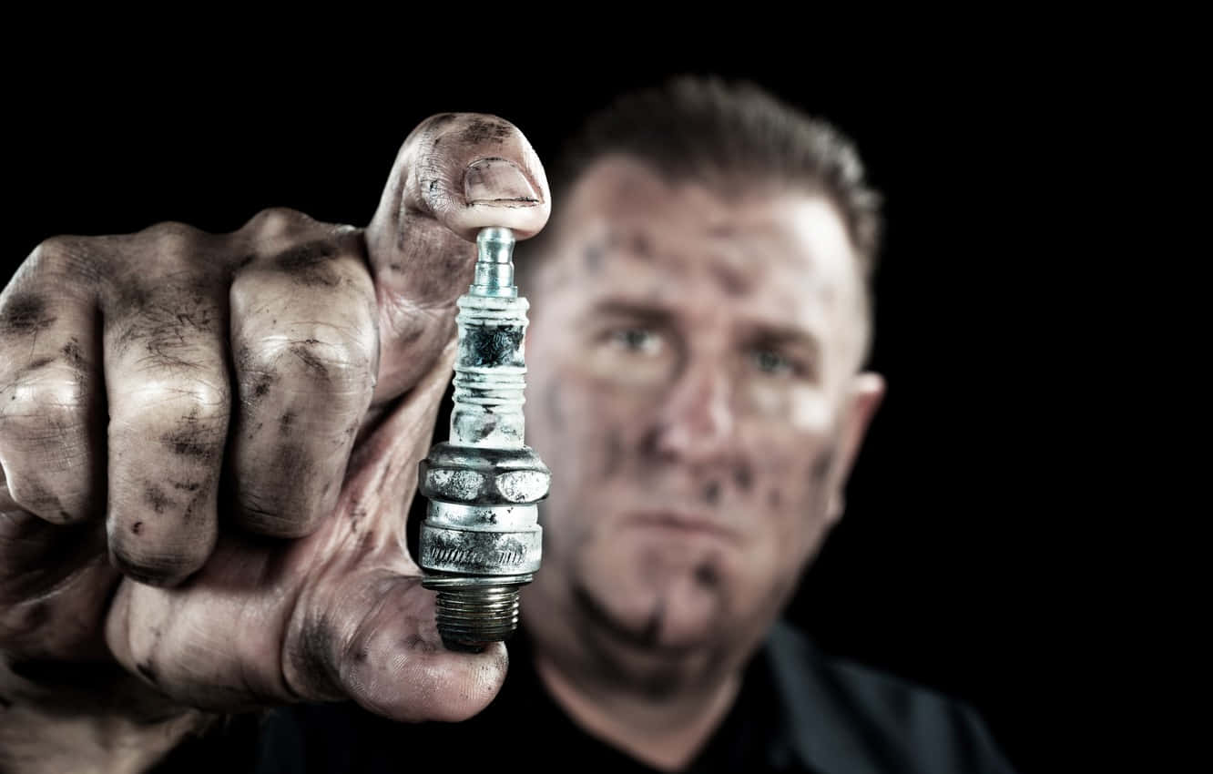 Dirty Man Holding Spark Plug Wallpaper