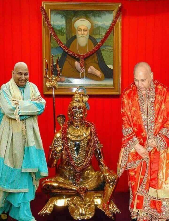 Divine Encounter: Guru Ji Engaging In Deep Spiritual Commune With Hindu Deity Sculpture. Wallpaper