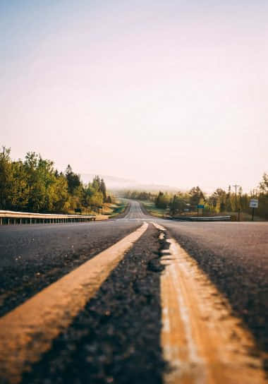 Empty Road With A Line Of Yellow Paint Wallpaper