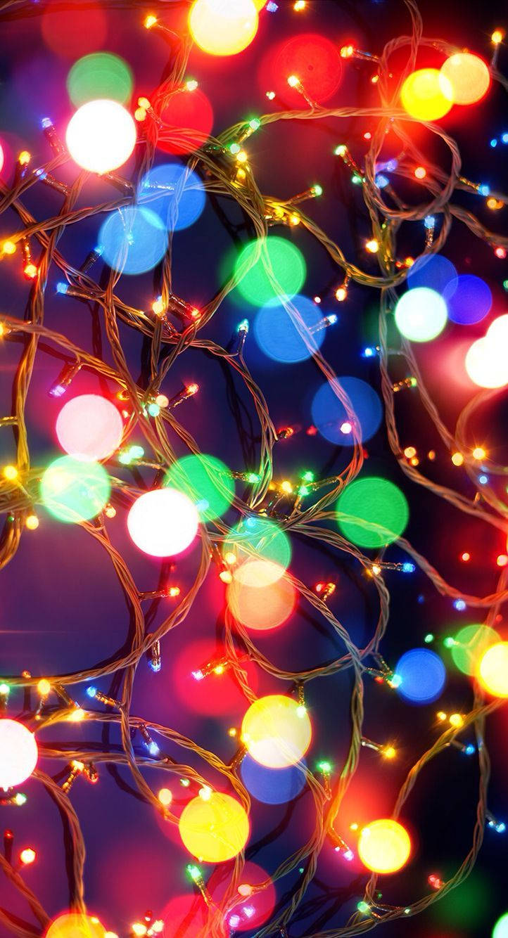 Enjoy A Festive Evening With Christmas Lights On Your Iphone Wallpaper