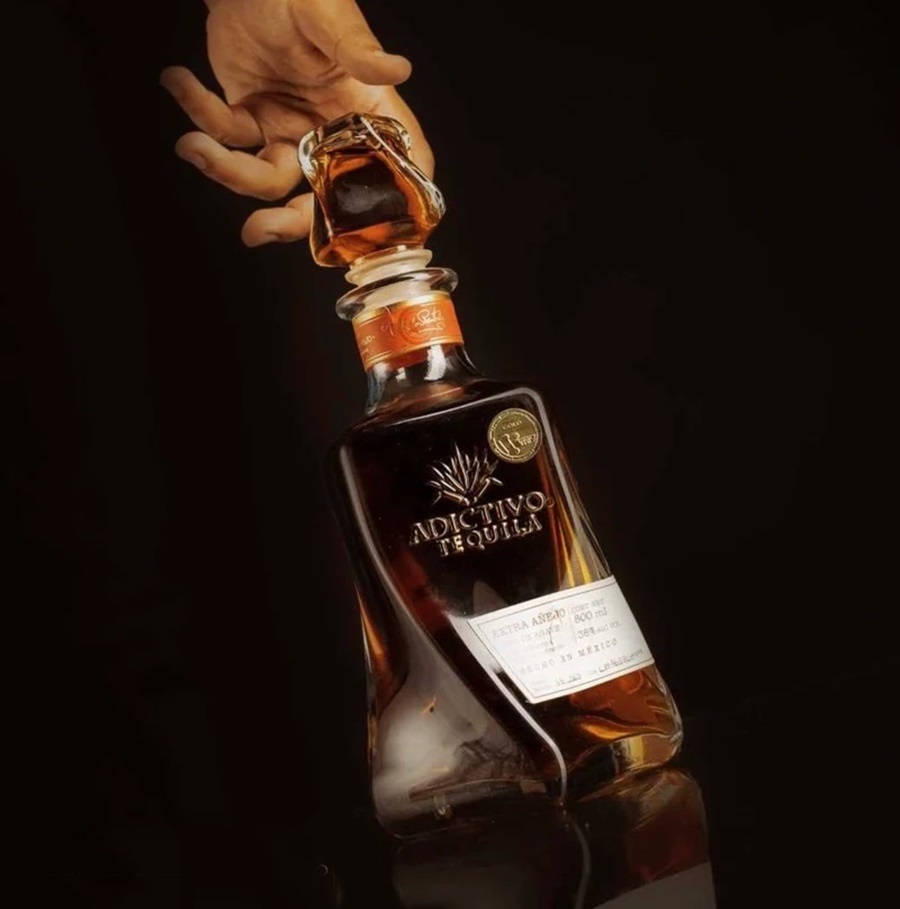 Exquisite Bottle Of Dark Amber Adictivo Tequila Reposado Wallpaper