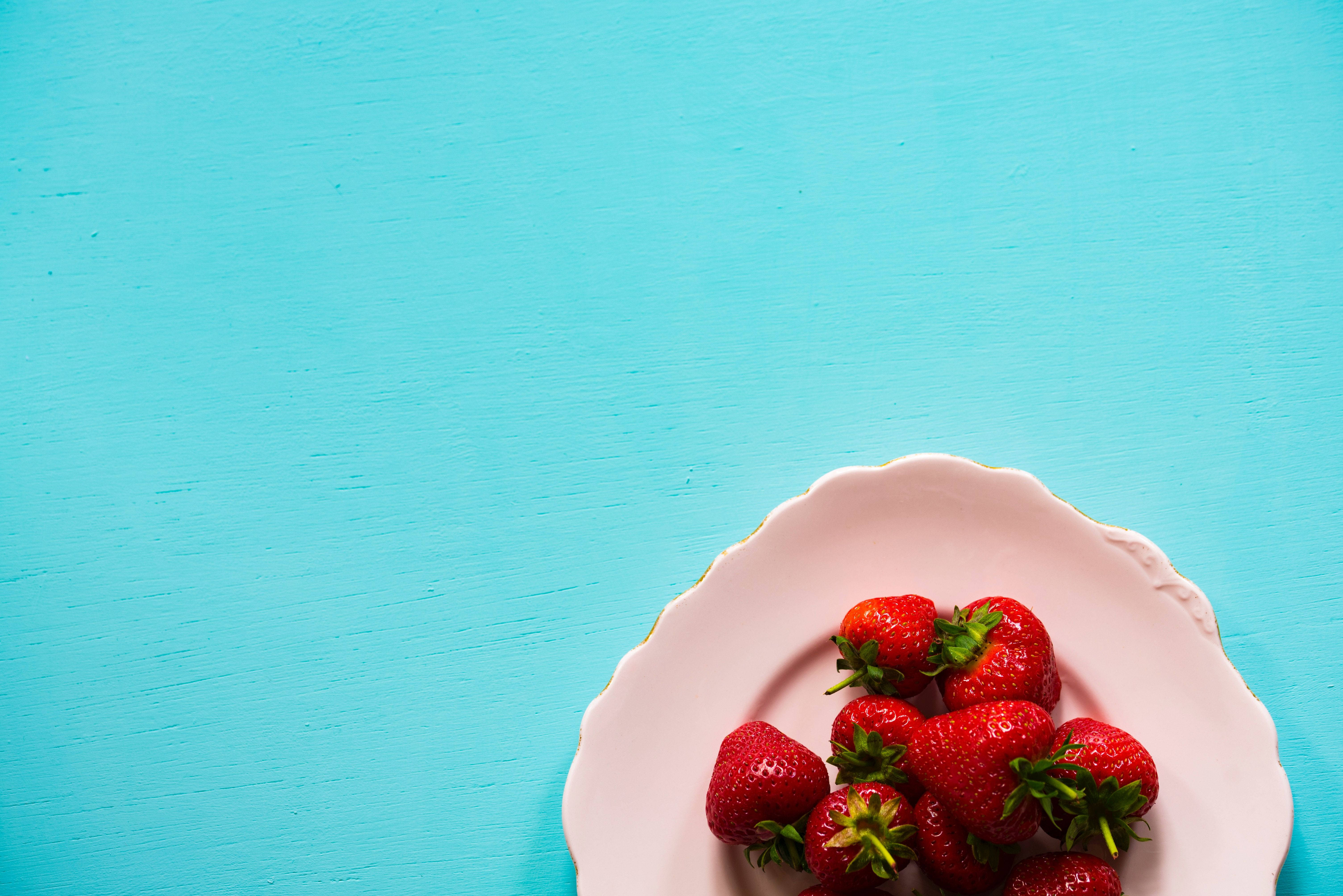 Fresh Strawberries On A Sapphire Blue Desk Wallpaper