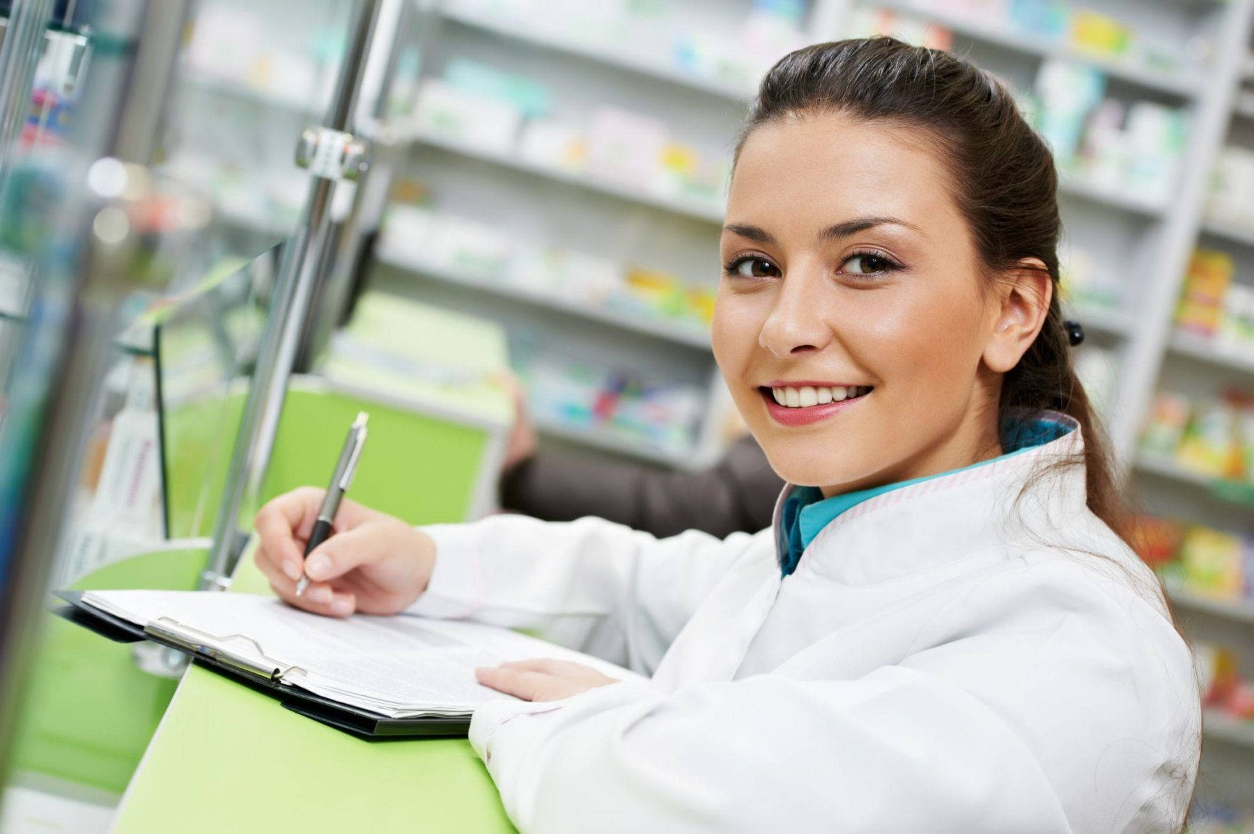 Friendly Female Pharmacist In A Pharmacy Wallpaper