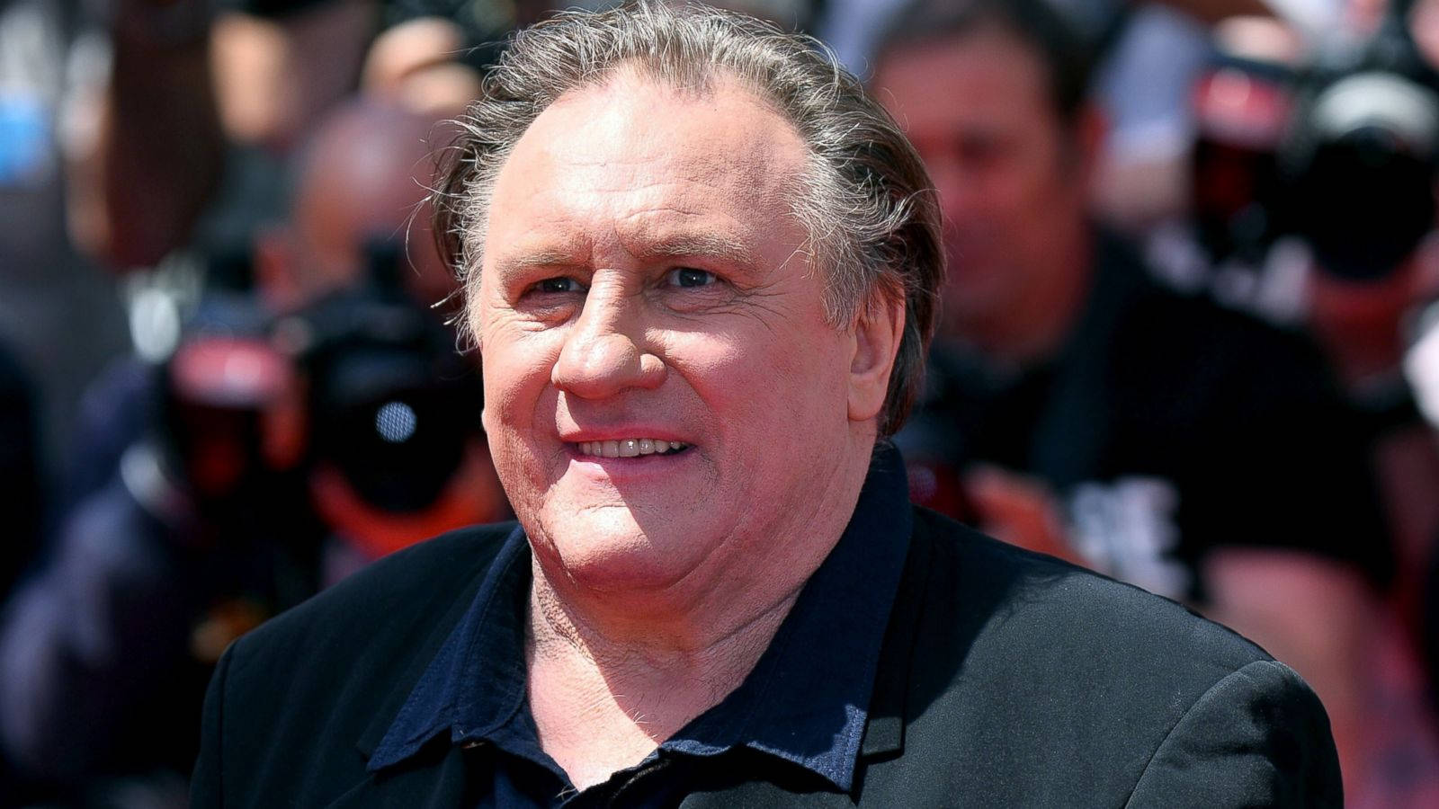 Gérard Depardieu Smiling With Press Wallpaper