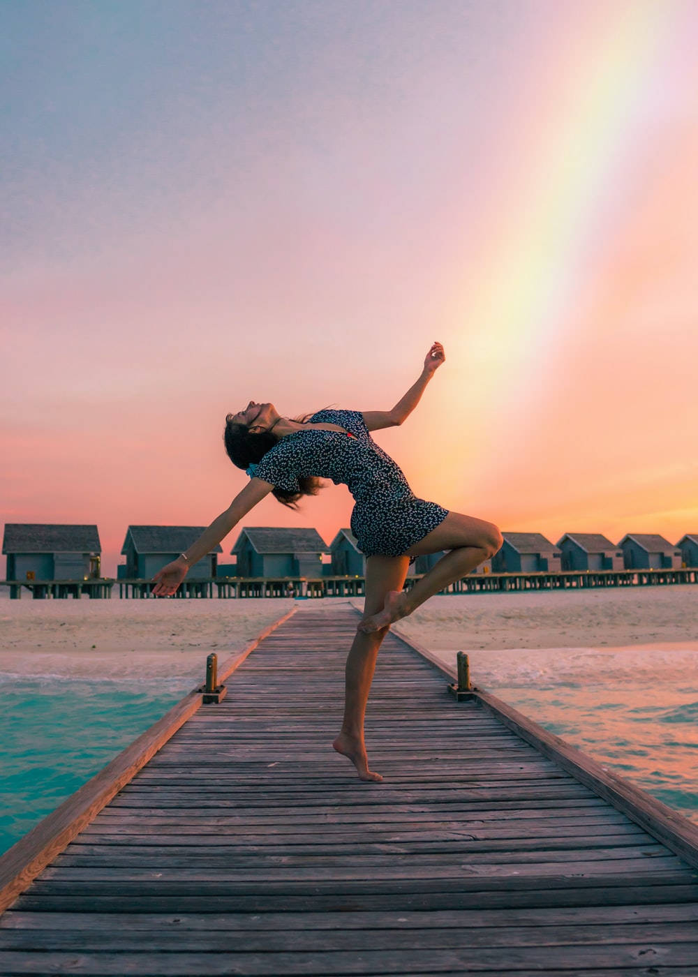 Graceful Dance Duet Overlooking A Rainbow Ocean View Wallpaper