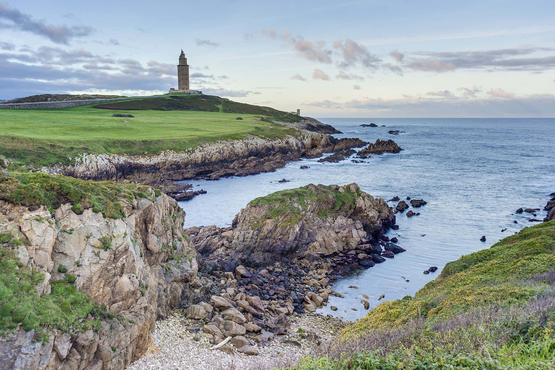 Grassy Green Landscape Around The Tower Of Hercules Wallpaper