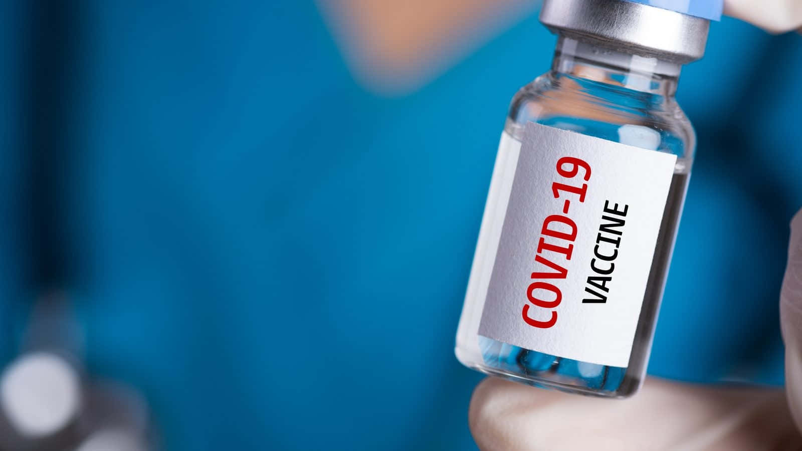 Healthcare Worker Holding A Dose Of Covid-19 Vaccine In A Vial. Wallpaper