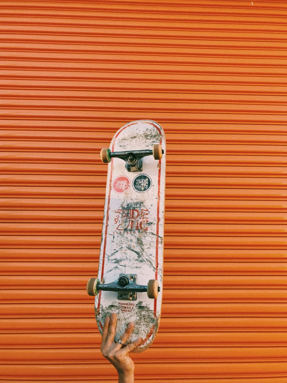 Holding Up Retro Skateboard Orange Wallpaper