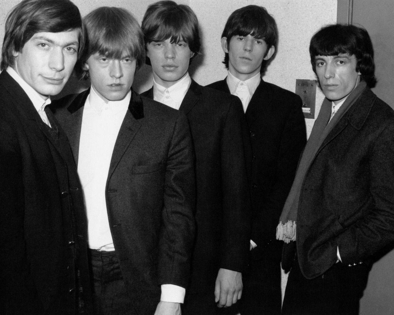 Iconic Rolling Stones In Black Suits Wallpaper