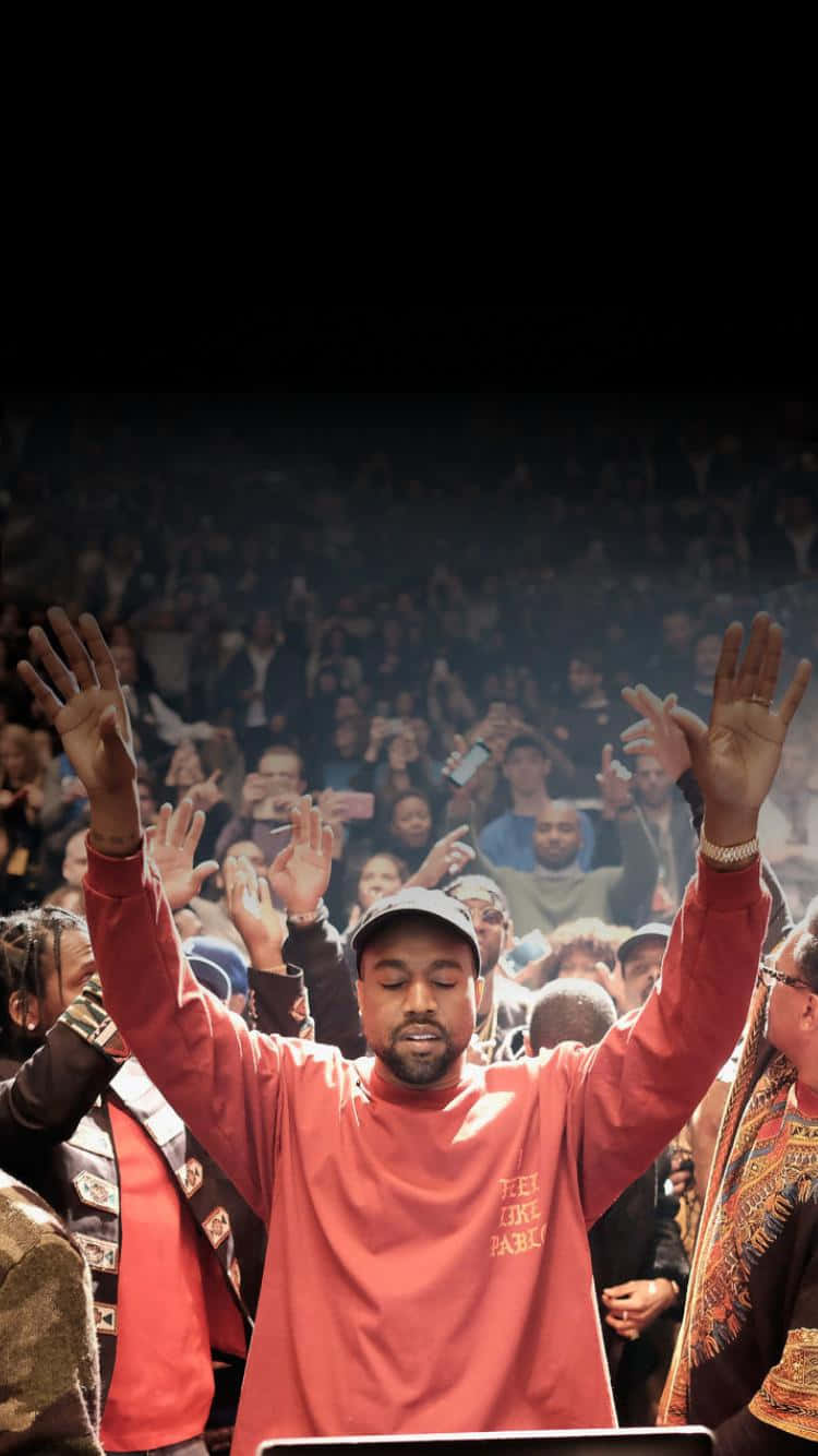Kanye West At A Concert With His Hands Up Wallpaper