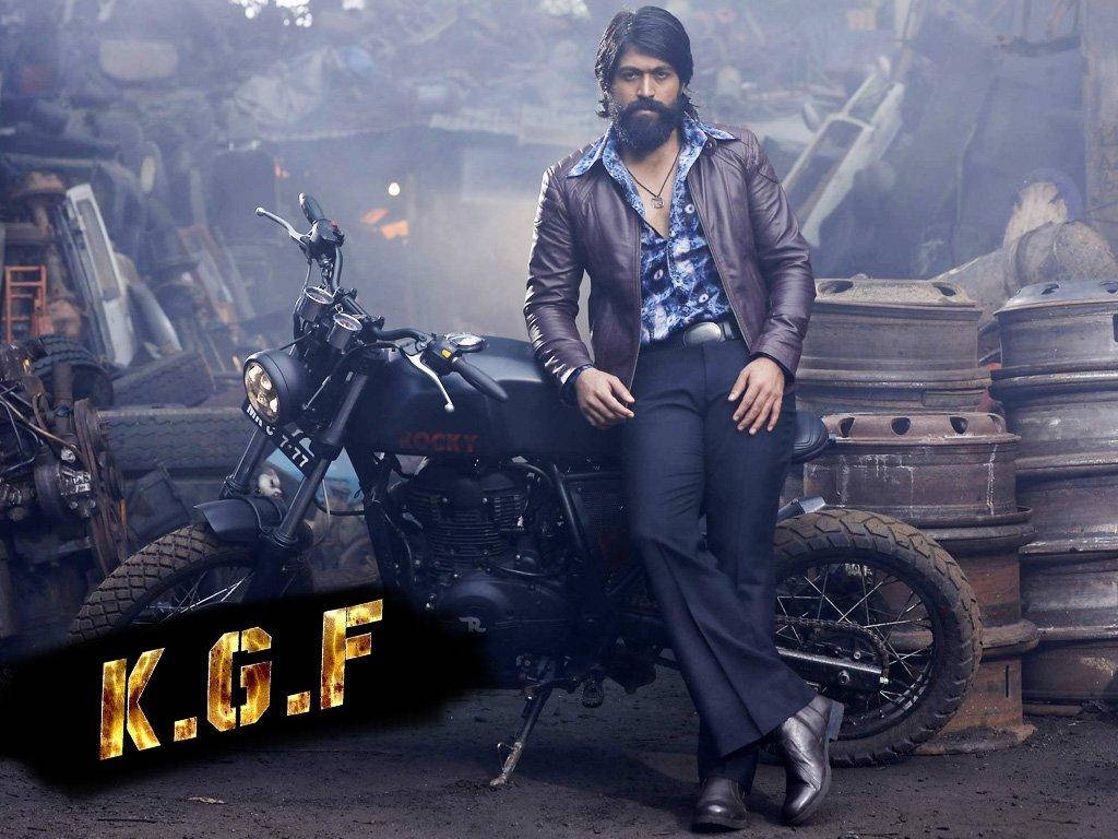 Kgf Rocky Bhai Leaning On Motorcycle Wallpaper