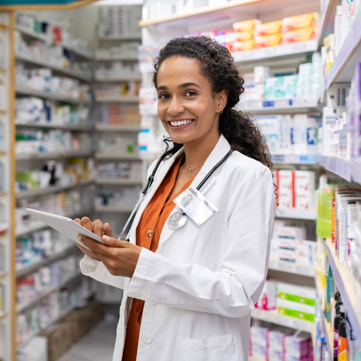 Lady Pharmacist Smiling Holding An Ipad Wallpaper