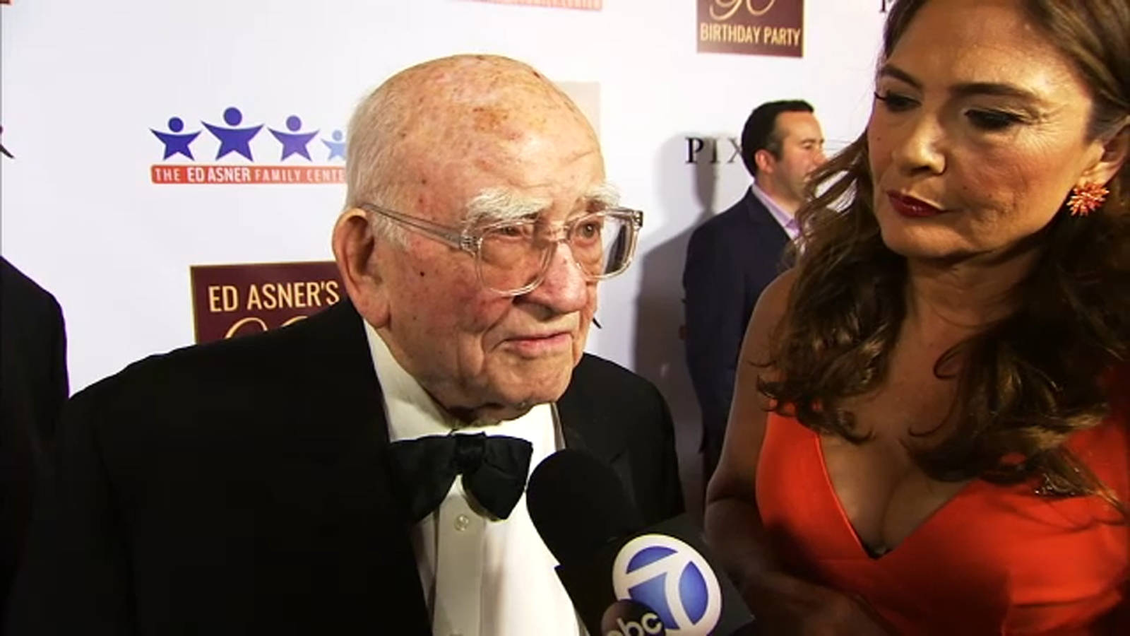 Legendary Actor Edward Asner Engaging In A Friendly Conversation With A Reporter Wallpaper