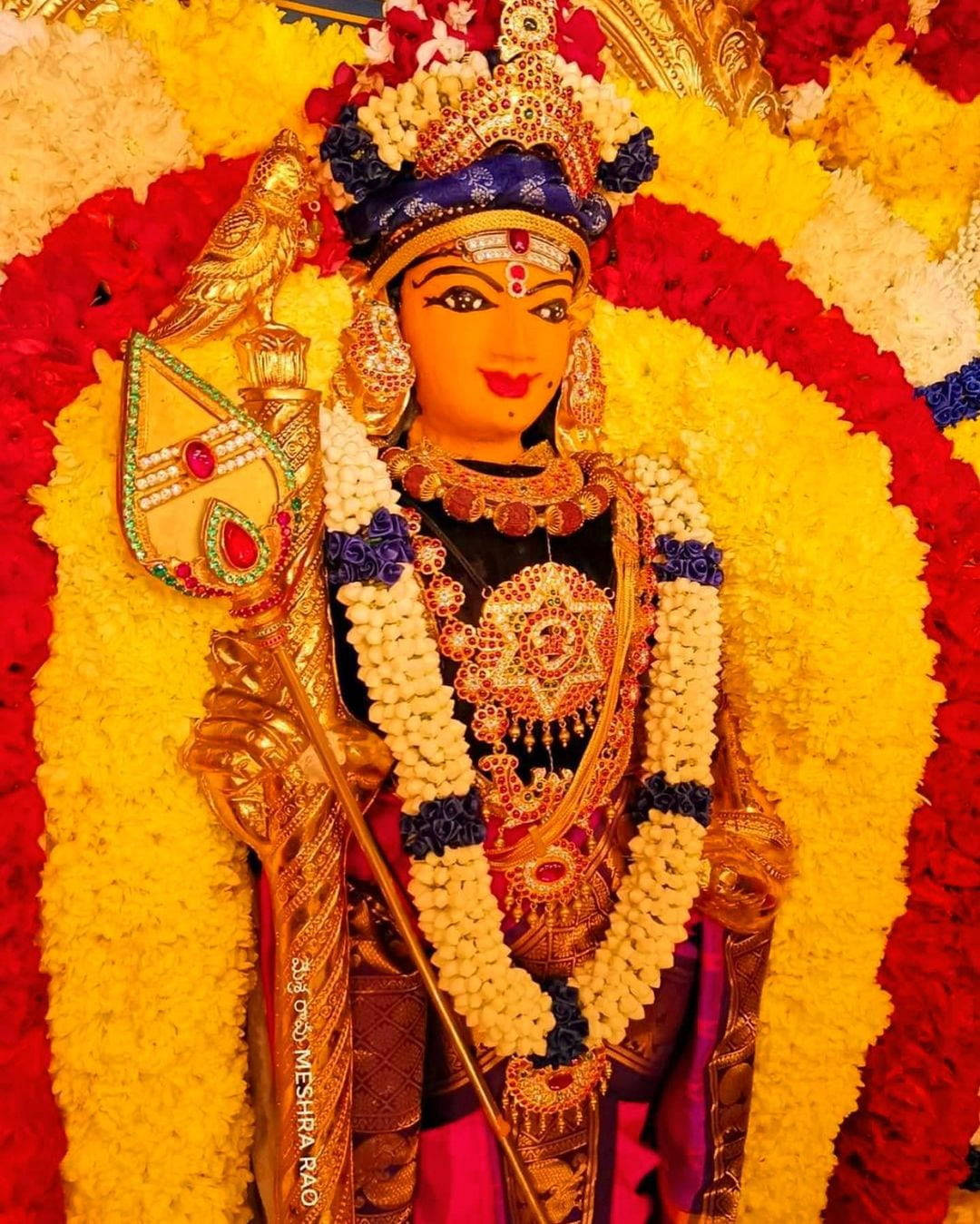 Lord Murugan Adorned With Many Flowers Wallpaper