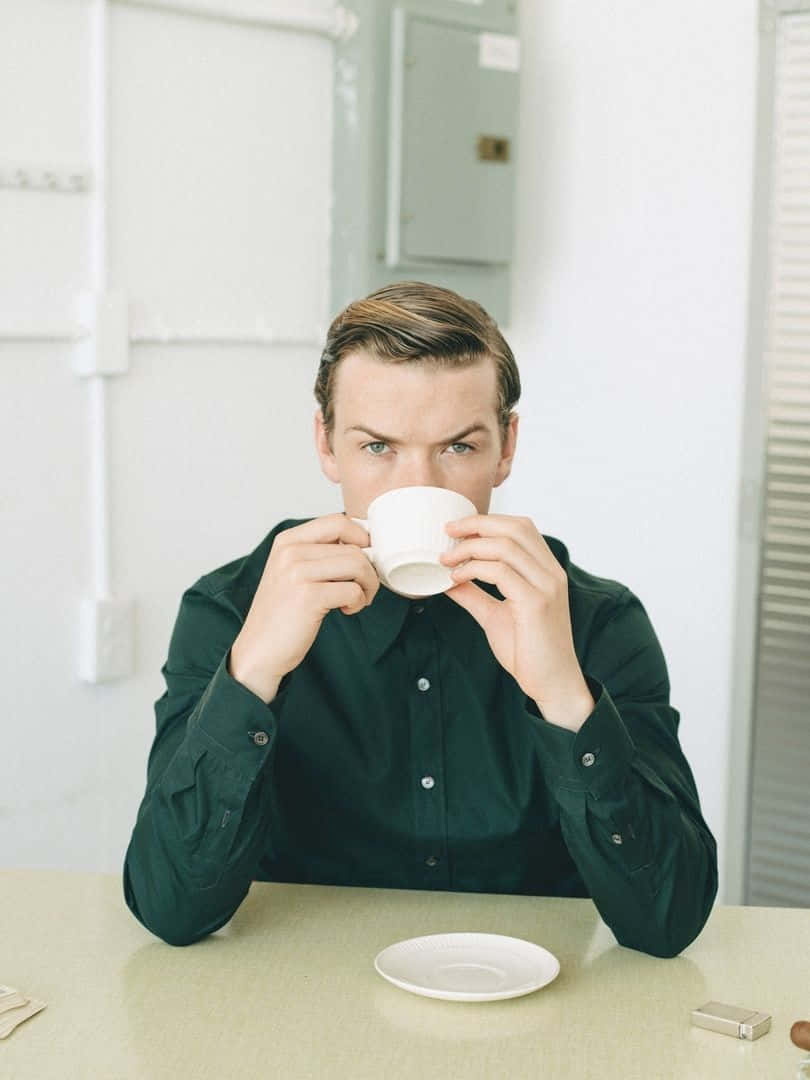 Man Drinking Coffeeat Table Wallpaper