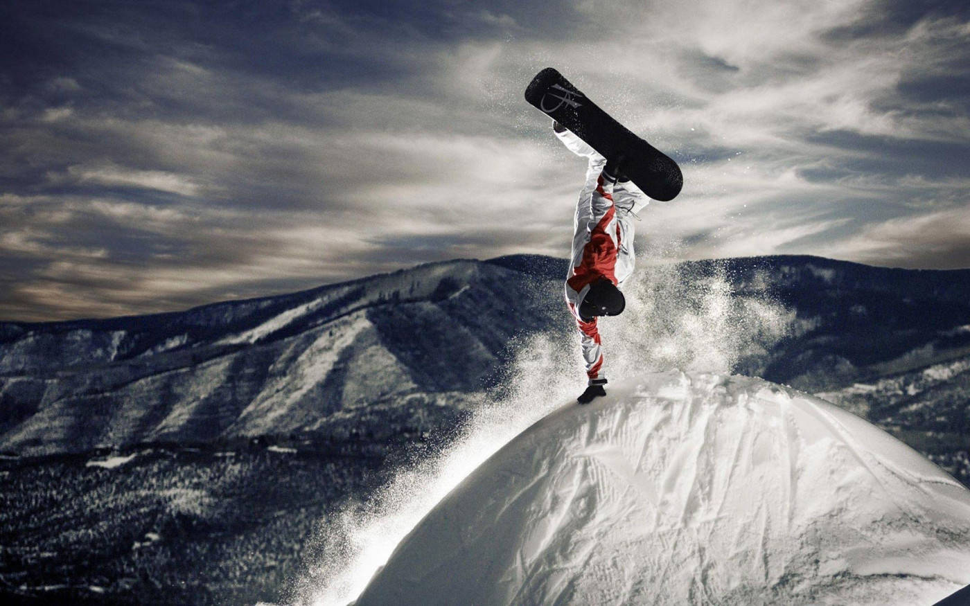 Man With Snowboard Leaping Over Mountain Wallpaper