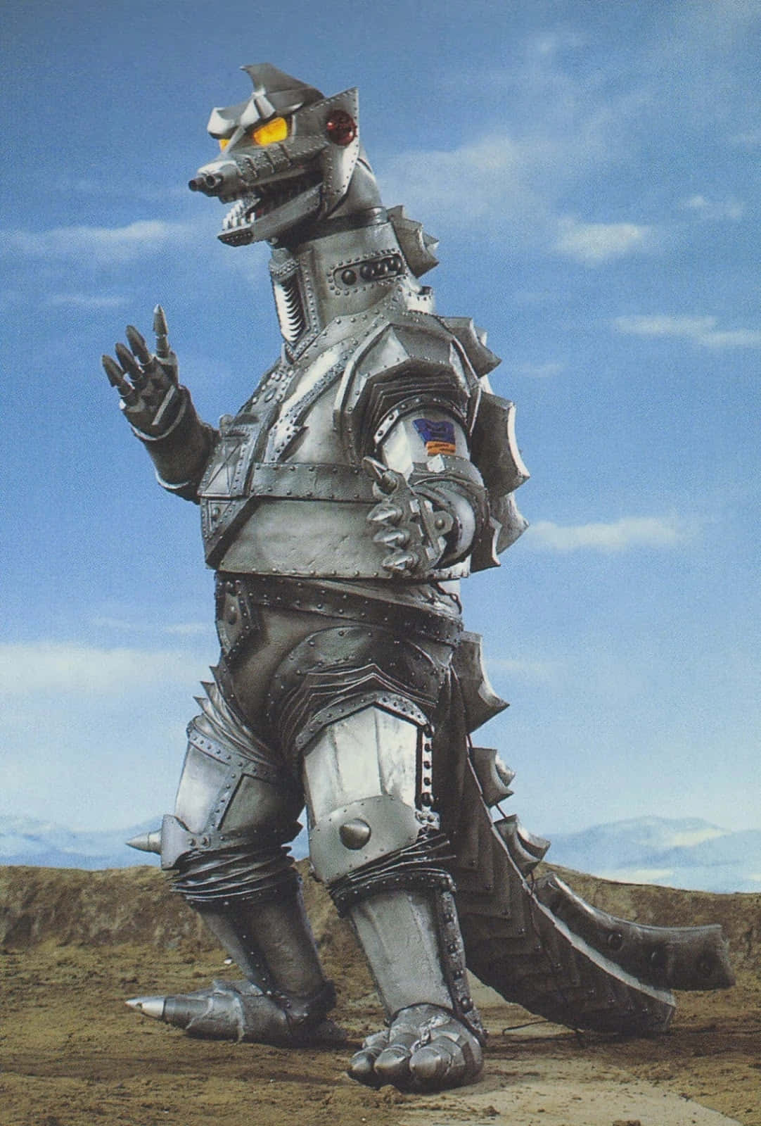 Mechagodzilla, The Powerful Robotic Titan, Stands Tall Against A Flaming Backdrop. Wallpaper