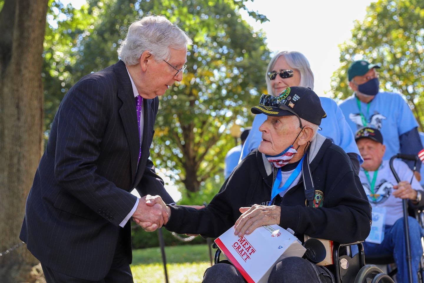 Mitch Mcconnell Assisting Elderly Man In Wheelchair Wallpaper