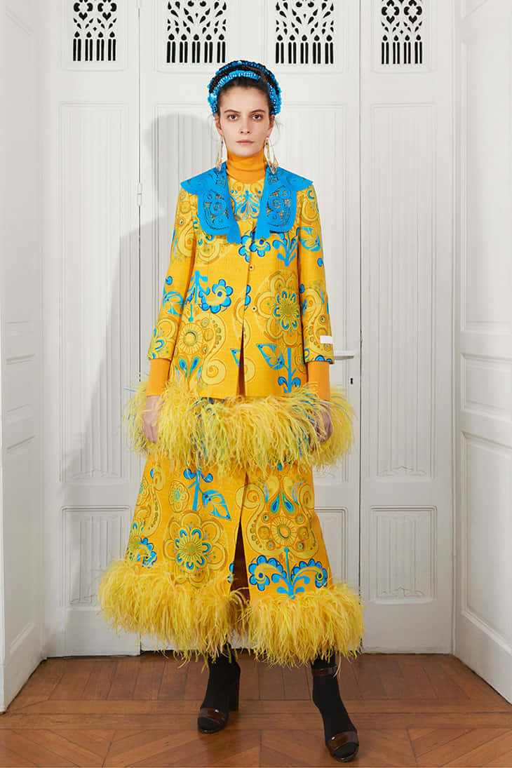 Model Wearing Yellow And Blue Patou Ensemble Wallpaper