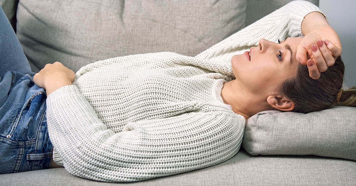 Nauseous Woman Lying With Hands On Head Wallpaper