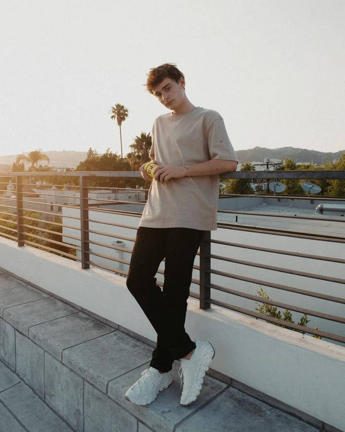 Noah Schnapp Leaning On Railing Wallpaper