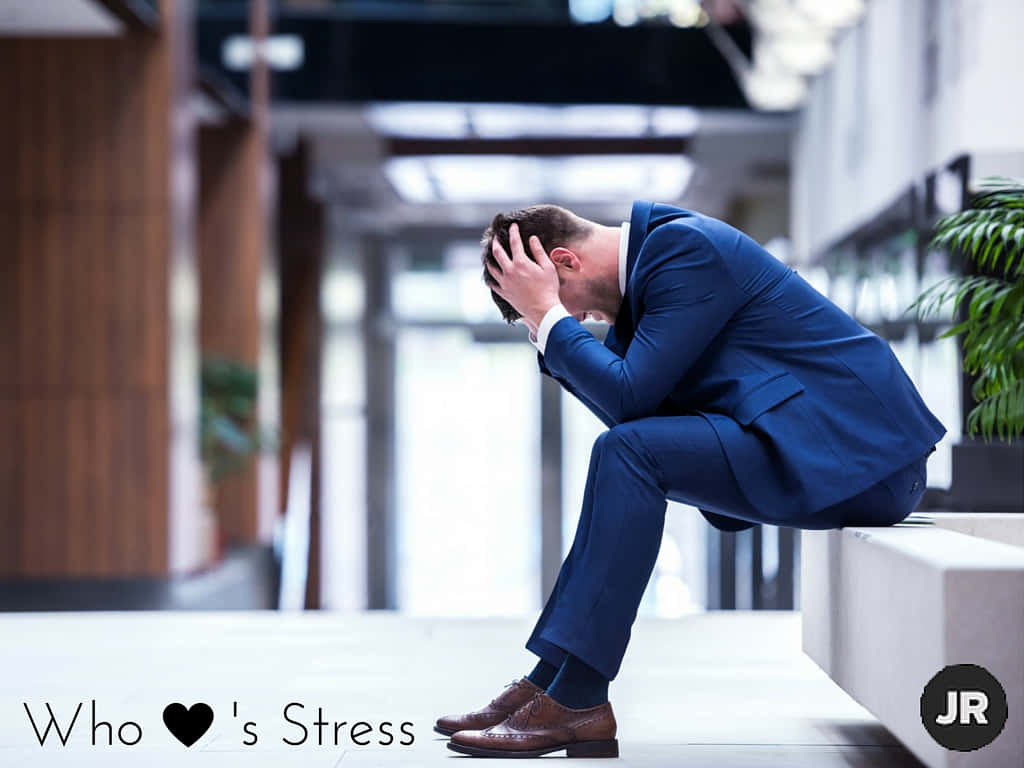 Overwhelmed Businessman Struggling With Stress Wallpaper