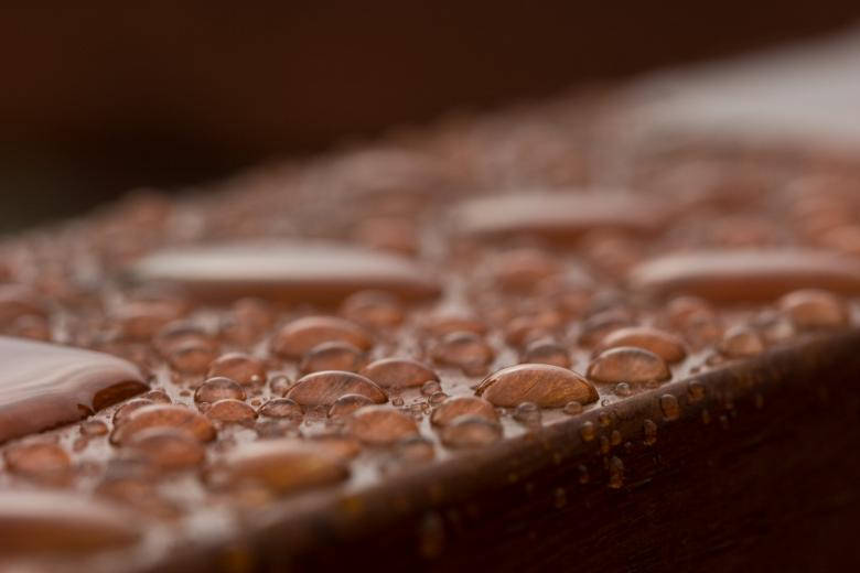 Pristine Water Droplets On Polished Wood Wallpaper