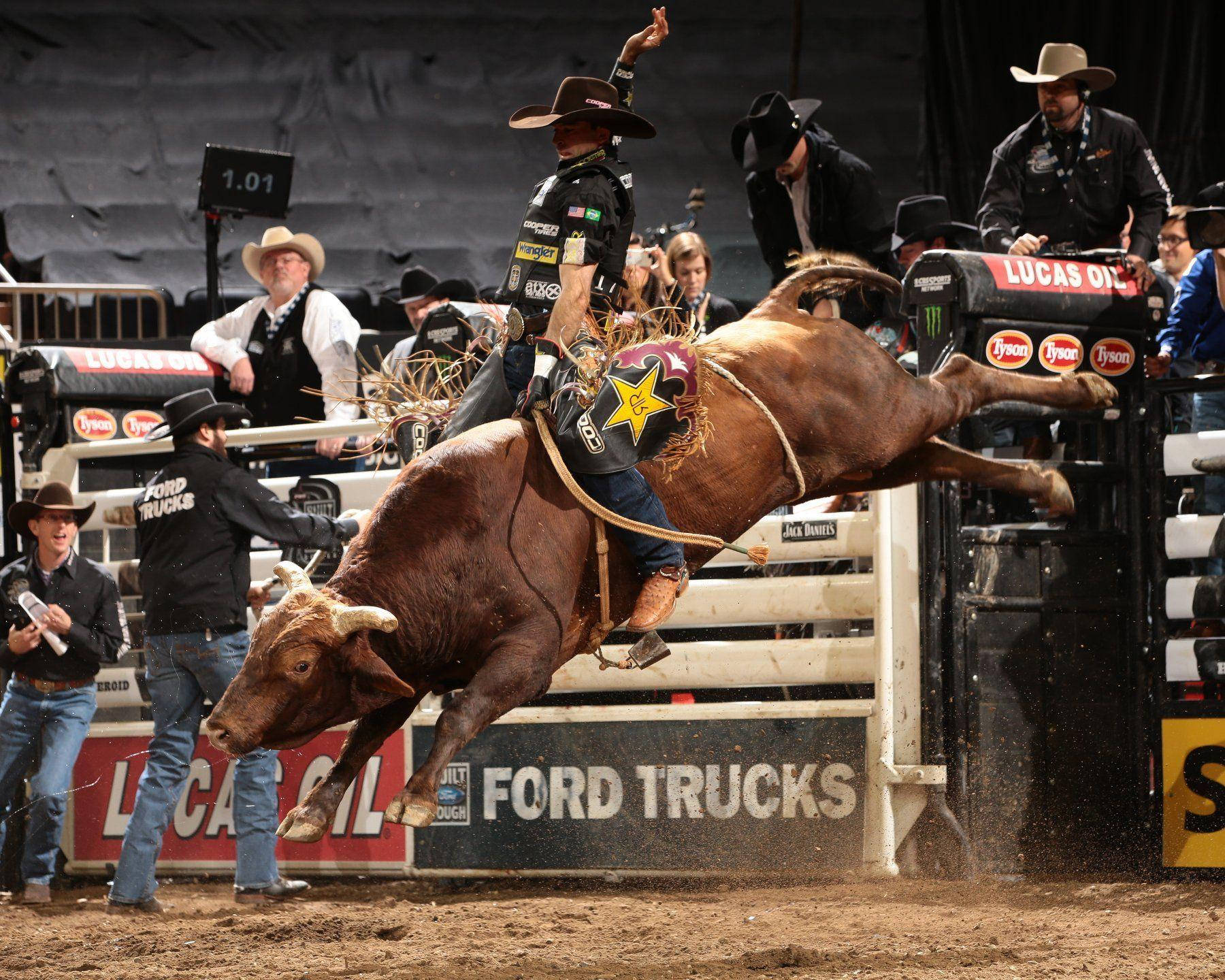 Professional Bull Rider Proudly Competing In An Arena Wallpaper