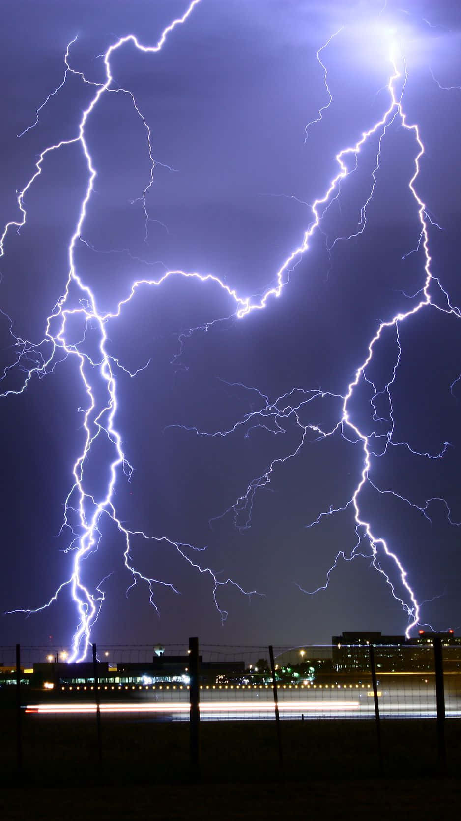 Purple Lightning Strike Against A Dark Sky Wallpaper