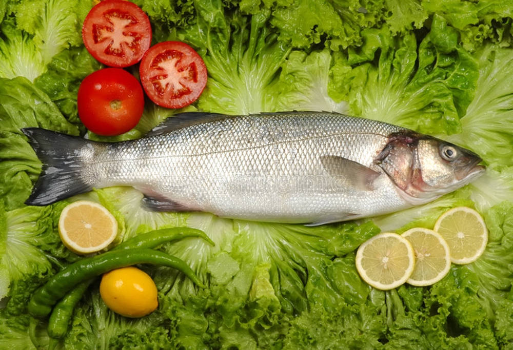 Raw Gray Mullet On Top Of Lettuce Wallpaper