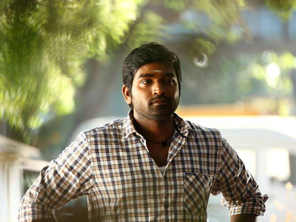 Reflective Vijay Sethupathi Posing Confidently With Hands On Hips Wallpaper