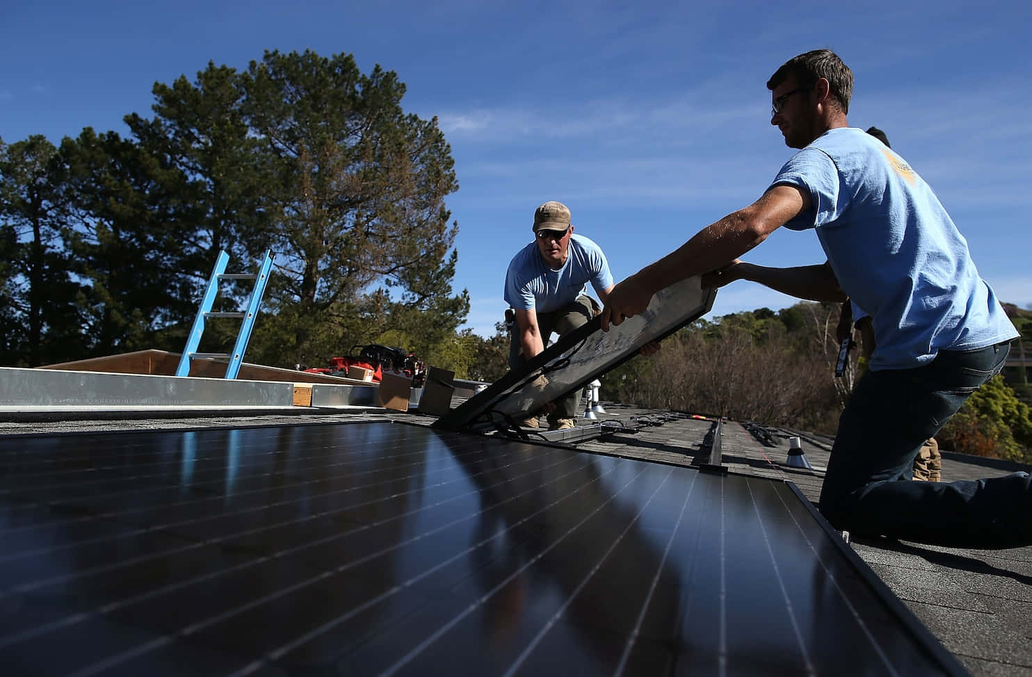 Renewable Energy In Action: Solarcraft Workers Installing Solar Panels Wallpaper