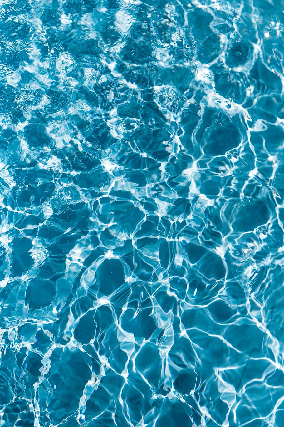 Shimmering Tranquility: A Glimpse Of Brilliant Blue-green Pool Water Wallpaper