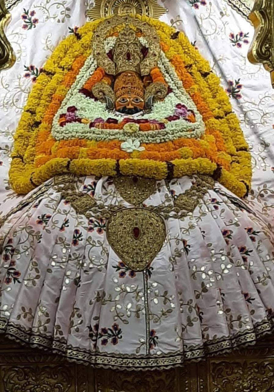 Shyam Baba In White Coat And Yellow Garland Wallpaper