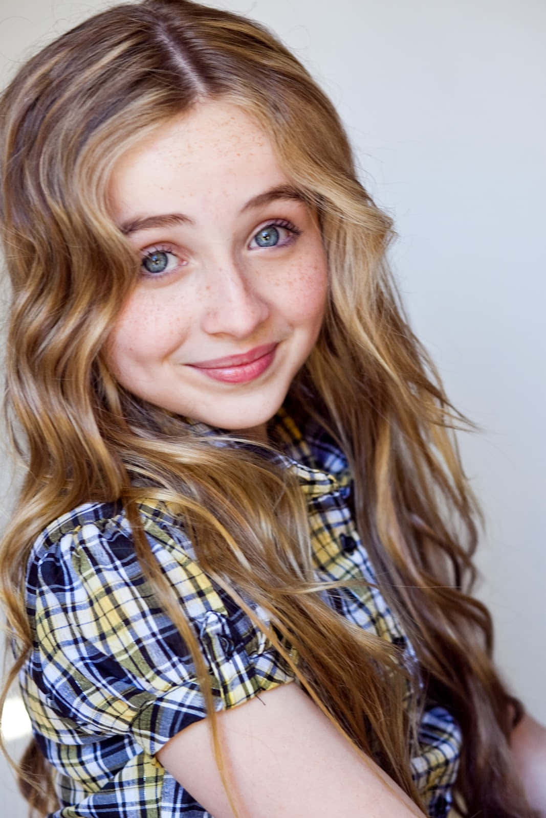 Smiling Young Girlwith Blue Eyes Wallpaper