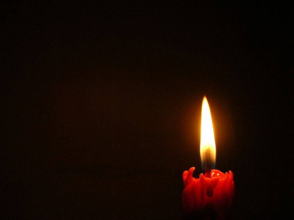 Solemn Black Day With Burning Red Candle Wallpaper