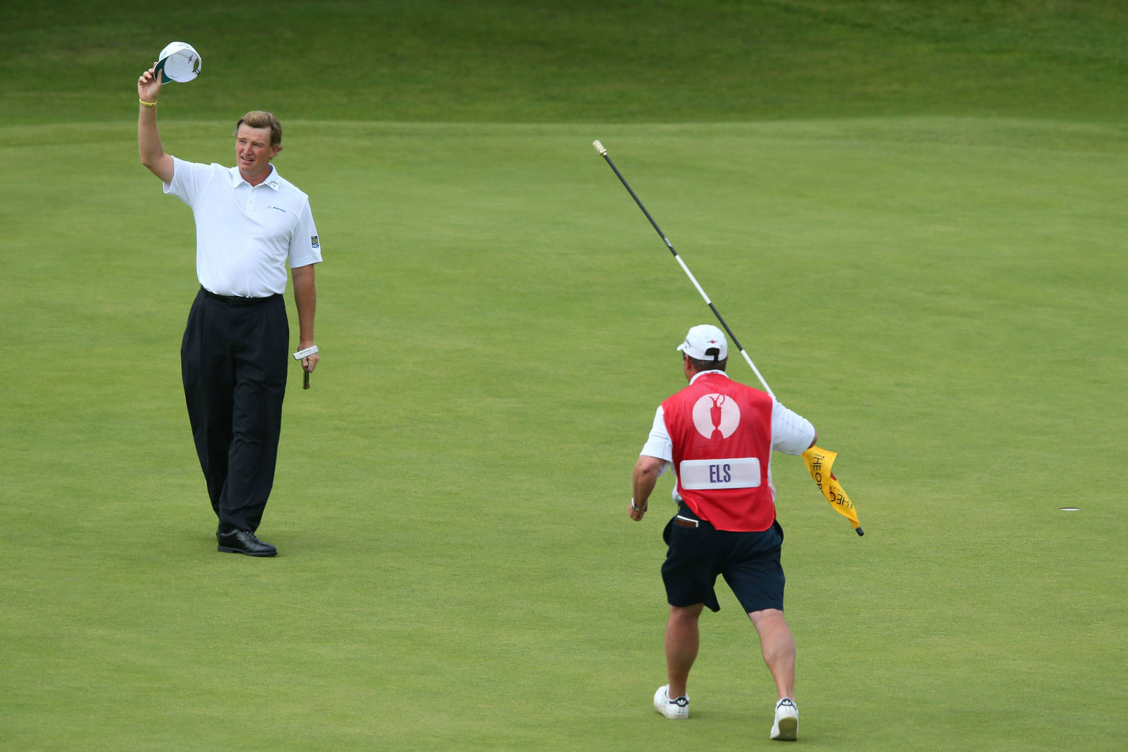 South African Pro Golfer Ernie Els With His Caddy On The Golf Course Wallpaper