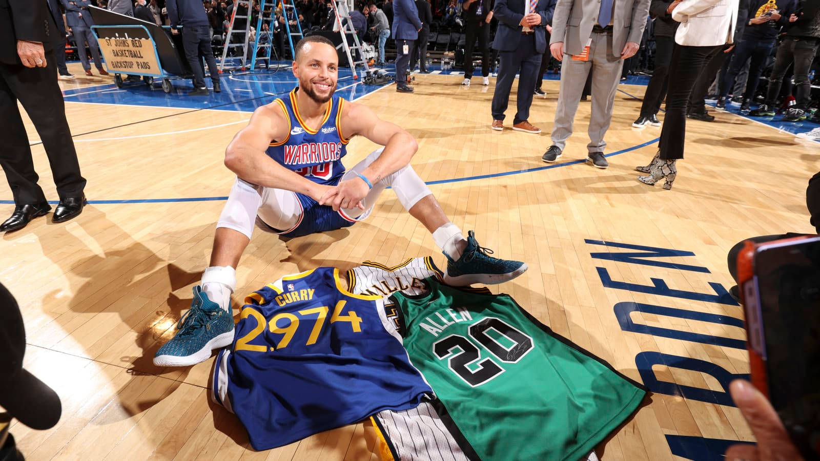 Steph Curry On The Floor With Jerseys Wallpaper