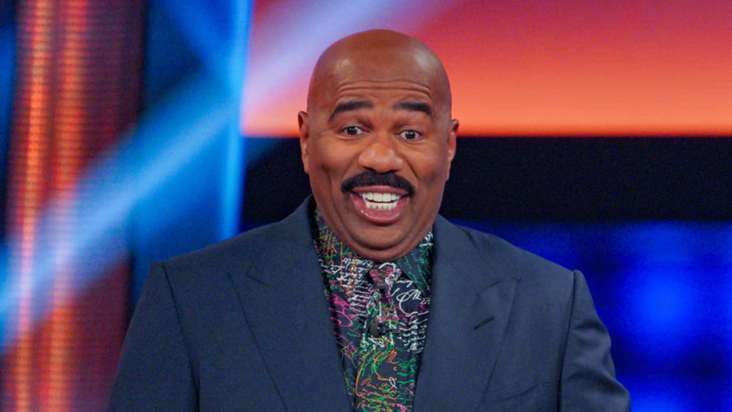 Steve Harvey Smiling In A Colorful Shirt Wallpaper